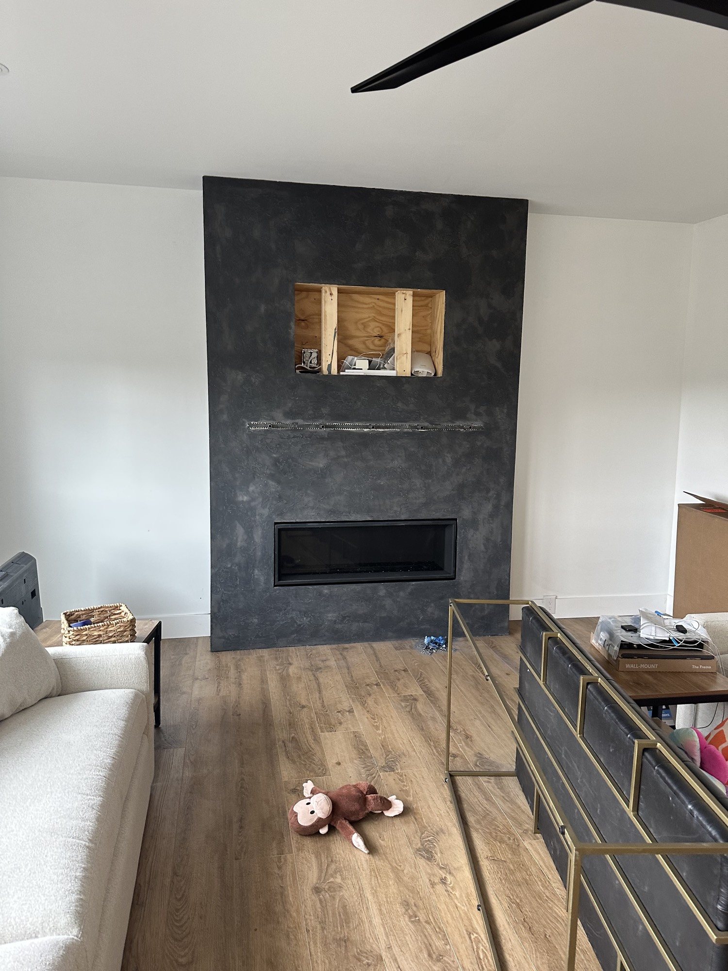 Charcoal plaster fireplace before television installation